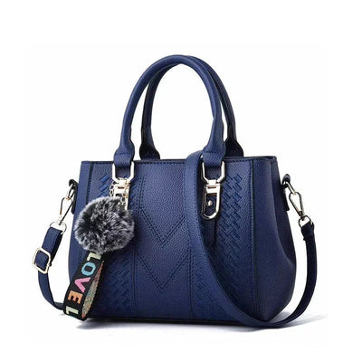 Blue handbag with a decorative keychain on a white background