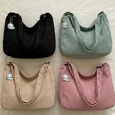 Four handbags in black, green, beige, and pink on a light background