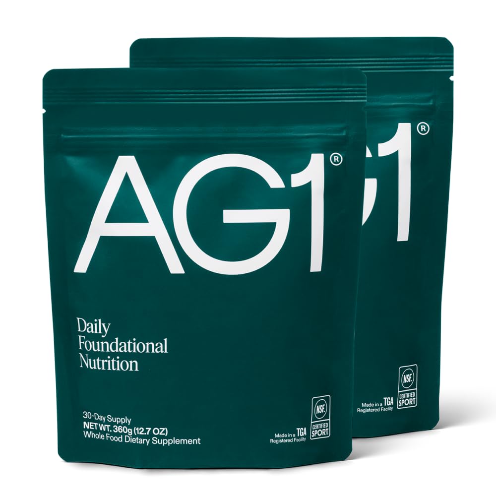 Two green AG1 supplement packages on a white background